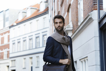 Smart man in scarf in city