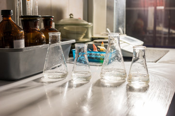 Beakers with transparent liquid. Flasks on the table. Workplace of chemist. Samples of water for research.