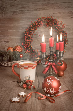 Hot tea, Christmas cookies and candles on decorated table