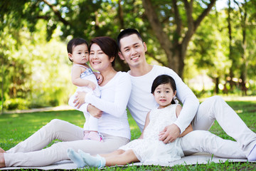 Young happy Asian family enjoying a sunny day at the park.