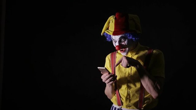 Evil scary clown dials the phone number to scare you. HD.