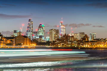 Fototapeta premium Blurred ferry light trails with London City skyline, night view