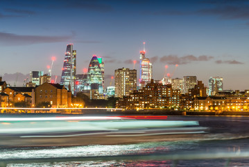 Blurred ferry light trails with London City skyline, night view