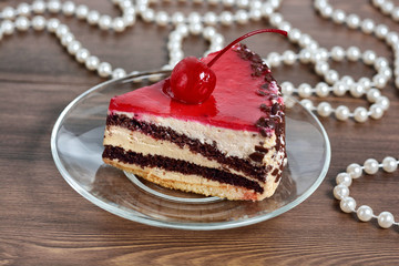 Delicious chocolate-cherry cake on plate on table 