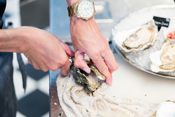 Shucking fresh oysters with a knife
