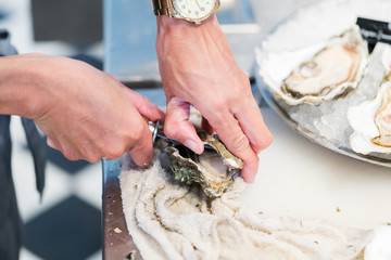 Shucking fresh oysters with a knife
