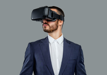 A man in a suit with virtual reality glasses on his head.