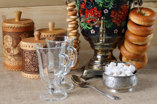 Расписной самовар, кружки, сахарница, туеса, баранки.