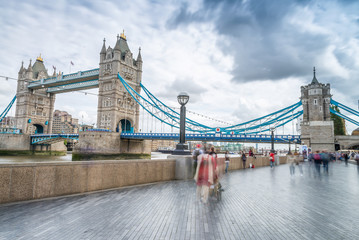 Tourists along Tower Bridge in London. Blurred long exposure vie