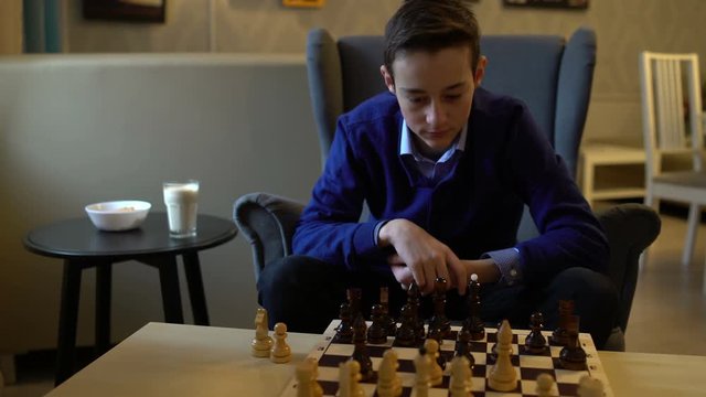 Teenager boy plays chess