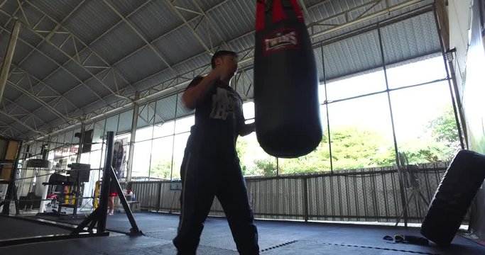 4k - asian man bench pressing and punching bag