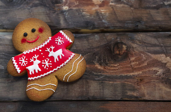 Smiling Christmas Gingerbread Men On Wooden Background.