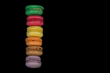Stacks of multicolored macaroon isolated on black background