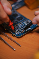 Engineer cheching computer board with multimeter