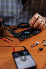 Fototapeta na wymiar Closeup of male hands soldering computer board