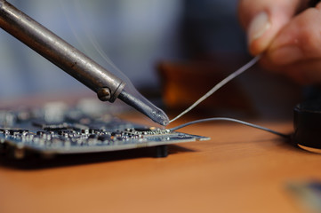 Soldering computer board, closeup