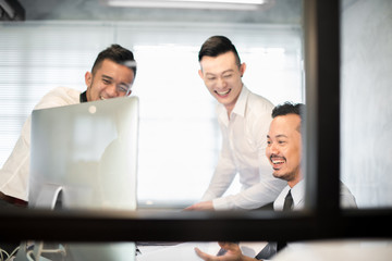 Young Asian coworkers sharing a light moment in the office.