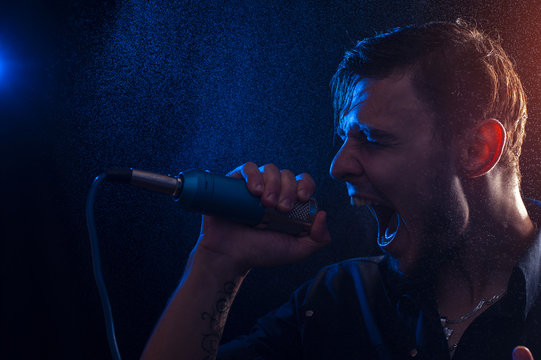 Young attractive male singer with microphone