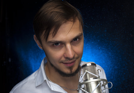 Portrait of youn attractive singer with microphone