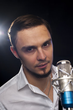 Attractive caucasian male singer with microphone
