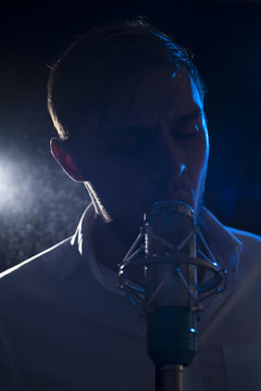 Cute male singer with microphone on stage