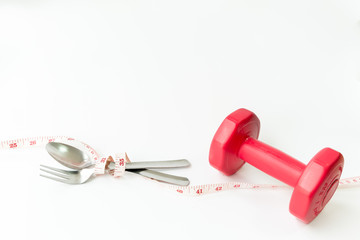 Healthy lifestyle fitness weight control concept. Closeup fork and spoon with measuring tape
