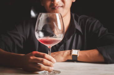 Asian man drinking red wine.