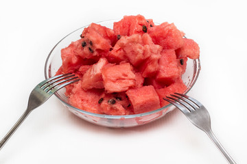 watermelon pieces in bowl with fork on white background