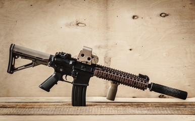 black assault rifle on a light wooden table
