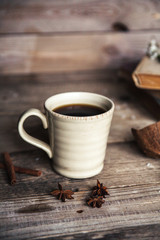 Large Cup of coffee on vintage wooden background. Spring flowers and books.