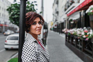 Outdoor fashion portrait of stylish pretty brunette woman walking in the city street
