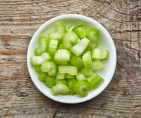 Bowl of celery on wooden table, from above