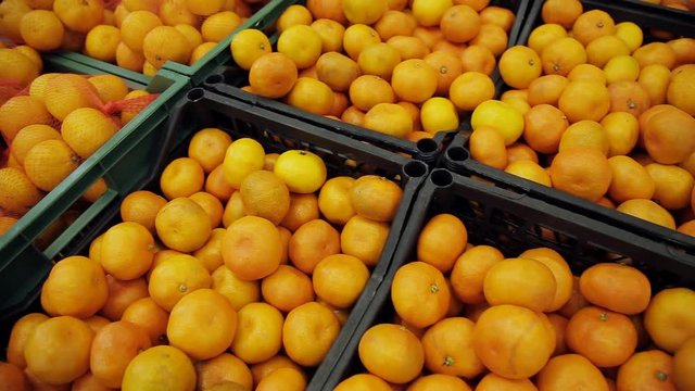 Many fruits mandarins lying in boxes in supermarket. orange fruit on the market