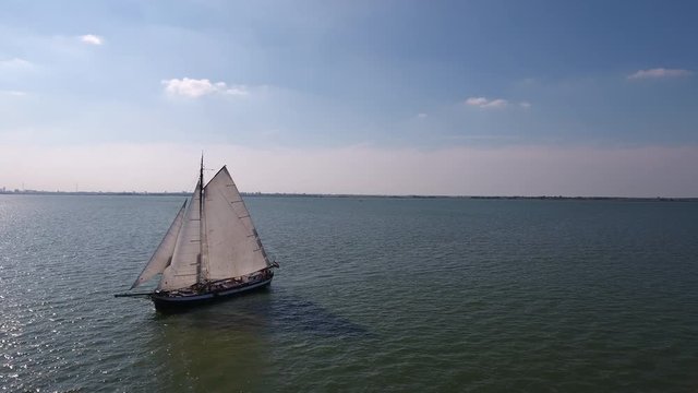 Historic Dutch sailboat at sea. Aerial perspective.