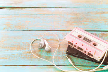 Top view (above) shot of retro tape cassette with earphone heart shape on wood table. Love music concept - vintage pastel color effect styles