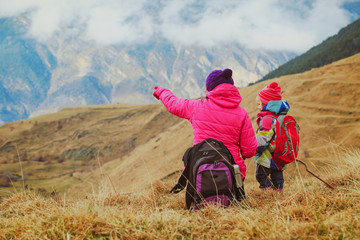 mother and little daughter travel in winter mountains