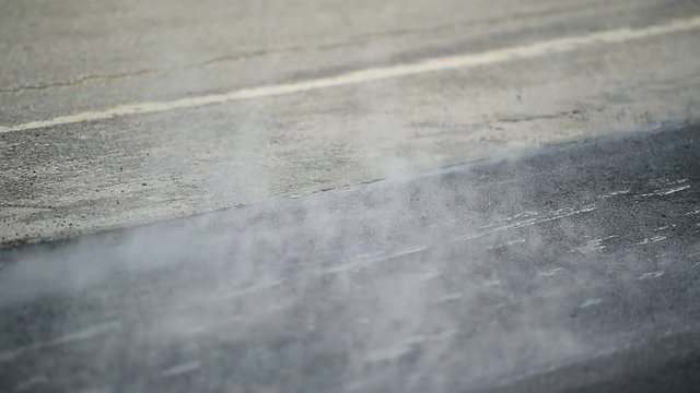 Asphalt paving with a steel wheel roller. Steam coming out from asphalt.
