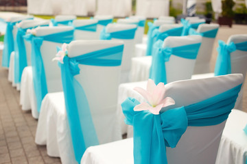 Beautiful wedding chairs with lily decoration on the ceremony