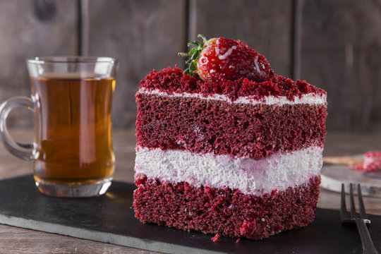 slice of red velvet cake with white frosting is garnished with strawberries  close up