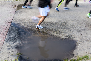 Runner marathon running next to puddle
