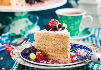 Piece of homemade  honey cake decorated with fresh fruits