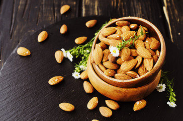 raw almonds in a wooden bowl selective focus