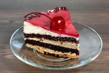 Delicious chocolate-cherry cake on plate on table