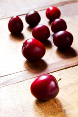 Many fresh juicy plums on wooden table