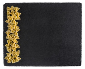 Pasta on a black slate board. Isolated on white background.