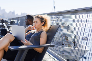 Young businesswoman working on the laptop outdoor