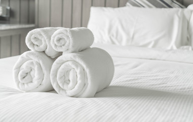 Fototapeta na wymiar White towel on bed decoration in bedroom interior