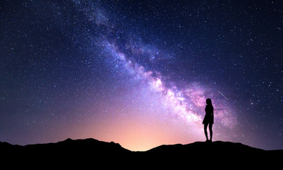 Beautiful purple Milky Way with standing woman. Colorful landscape with night sky with stars and...