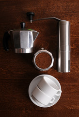 Geyser coffee, grinder and white cups on wooden table