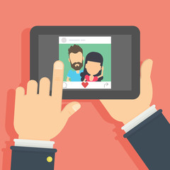 Couple on the screen. Hand holding mobile phone with photo of the couple. Concept of applications or social networks. Like button.